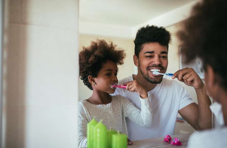 dad and his daughter brushing their teeth together in wilmington ma