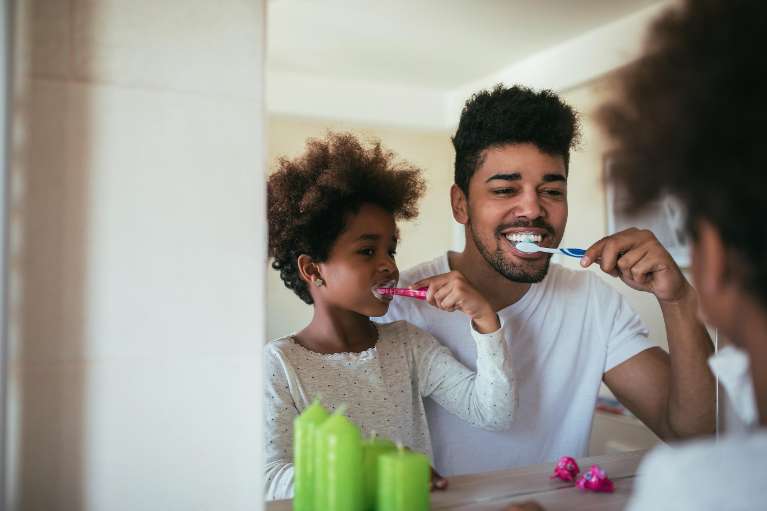 dad and daughter brushing their teeth together in wilmington ma